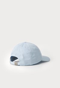 Light blue cotton baseball cap, with a curved brim, adjustable back strap, and embroidered ventilation holes. Simple, casual design.