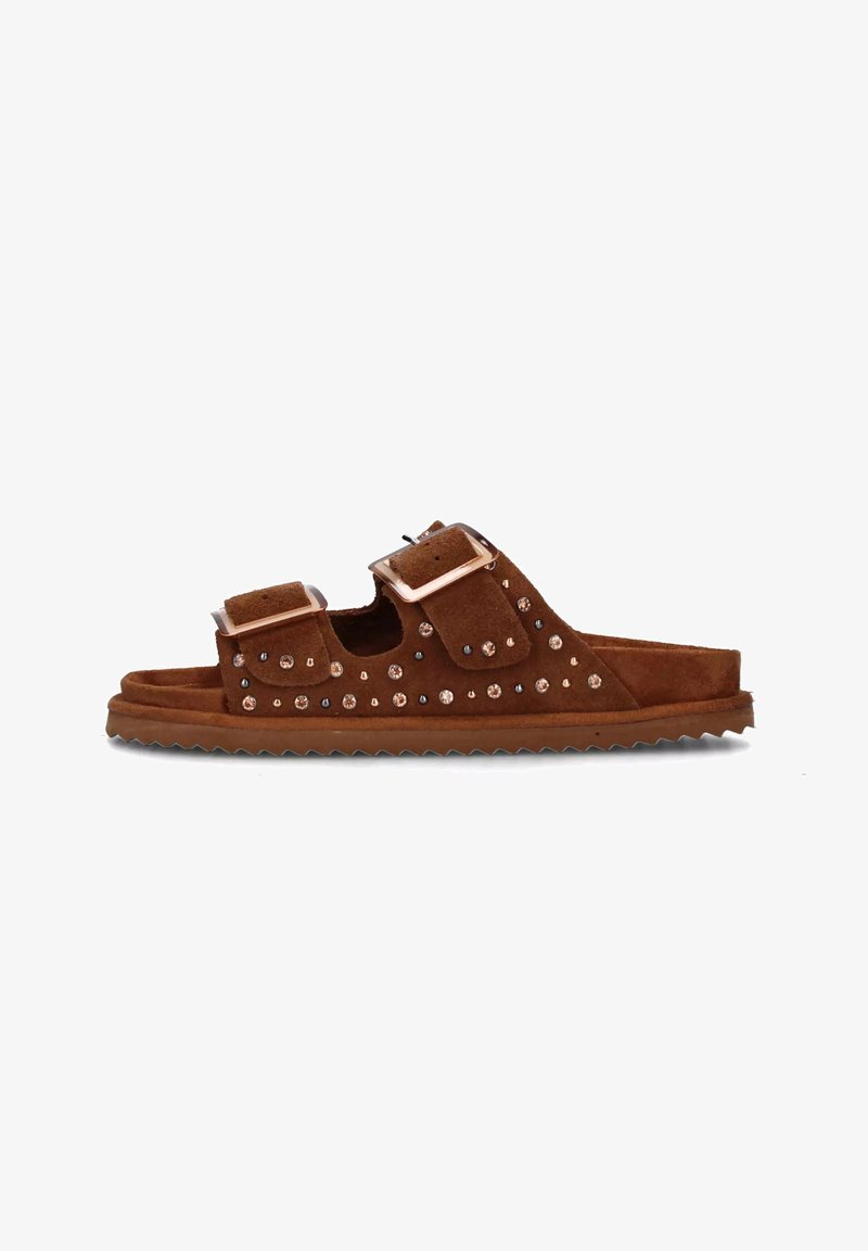 Sandal in suede marrone con due cinturini regolabili con fibbie in argento e borchie decorative lungo i lati. Suola texturizzata con grip.