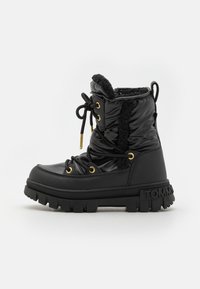 Stivaletto impermeabile nero con una texture morbida, fodera in pelliccia sintetica, dettagli in oro e una suola spessa e testurizzata. Design con lacci e dettaglio del logo.
