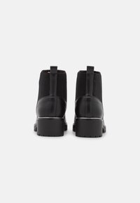 Schwarze Leder-Stiefeletten mit elastischen Seitenteilen, abgerundeter Spitze und profilierter Gummisohle. Zuglasche an der Rückseite für einfaches An- und Ausziehen.