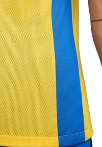Maglia atletica gialla e blu con texture in rete, pannelli di colore solido e bordi cuciti per una maggiore durata.