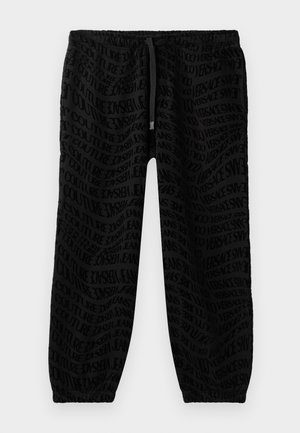 Black joggers with an all-over tonal logo pattern. Elastic waistband with adjustable drawstring and elastic cuffs at the ankles.