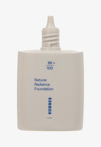 Hvid firkantet flaske med et skruehætte, prydet med blå tekst for "Natural Radiance Foundation" og "KORRES," med en buet kant i bunden.