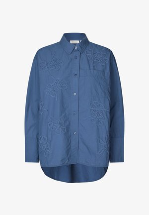 Blå bomuldsskjorte med lange ærmer, spids krave, brystlomme og hævet blomstret broderidetaljer foran. Knappelukning.