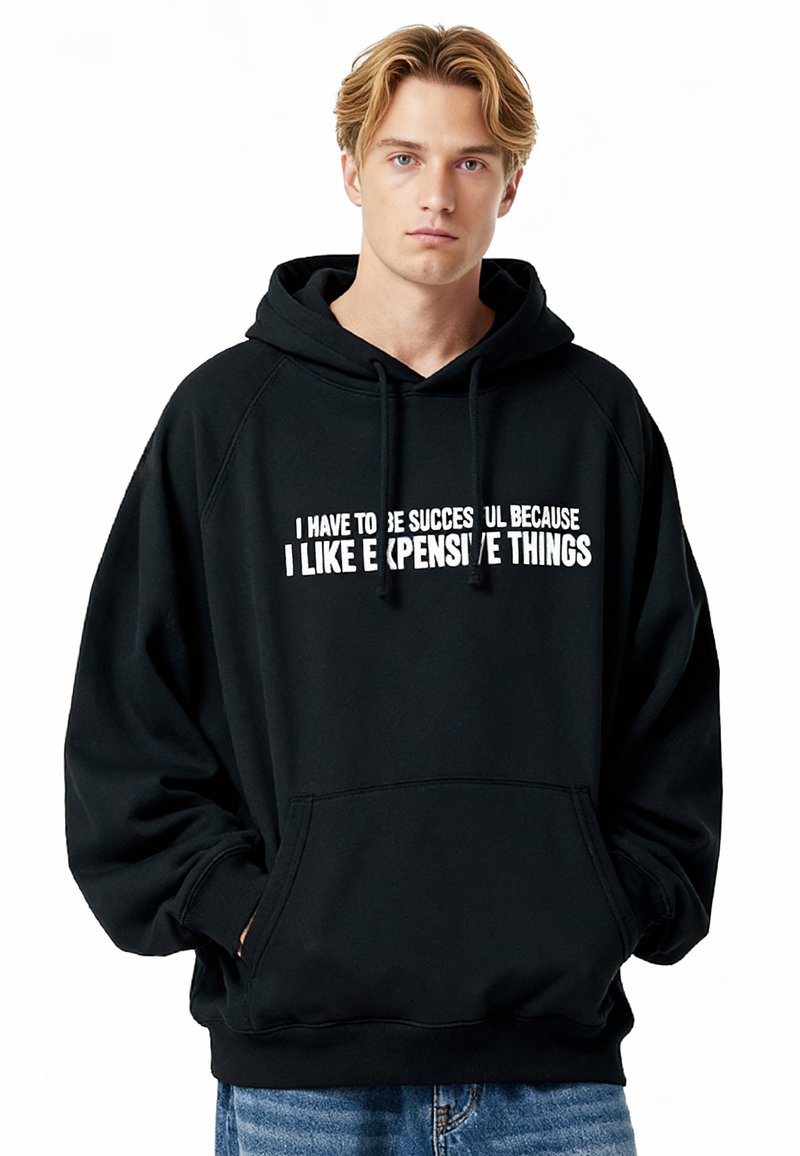 Sweat à capuche noir à coupe ample, avec une poche kangourou à l'avant et un imprimé texte blanc sur la poitrine. Texture de tissu doux.