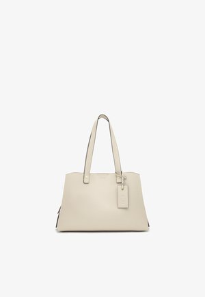 Borsa tote in pelle color crema con due spallacci e una targhetta rettangolare attaccata vicino alla parte superiore, su sfondo bianco.