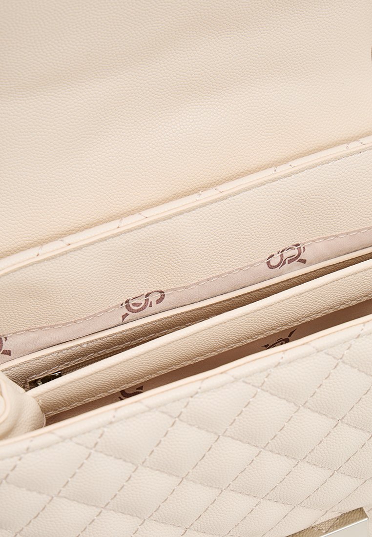 Borsa a tracolla beige trapuntata realizzata in pelle sintetica testurizzata. L'interno presenta una fodera liscia con un discreto motivo a logo e numerosi scomparti.