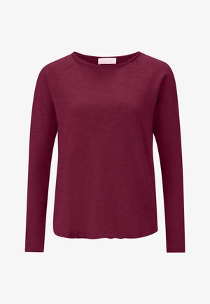 Camicia a maniche lunghe color borgogna con scollatura rotonda e tessuto morbido e texture. Caratterizzata da un orlo leggermente curvato e maniche raglan.