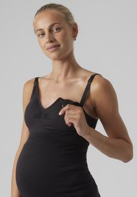 Zwarte zwangerschaps tanktop met verstelbare bandjes, voorzien van geplooide stof bij de buste en een aansluitend ontwerp voor comfort.