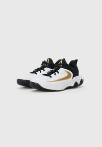 Baskets blanches de sport avec des accents noirs, un swoosh doré, une tige texturée et une semelle intermédiaire mouchetée. Présente une semelle en caoutchouc noir pour une meilleure traction.