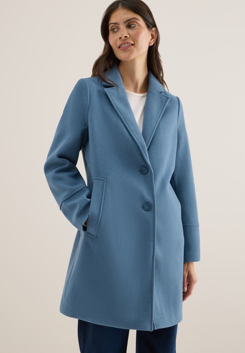 Abrigo de lana azul claro con cuello de solapa, dos botones y bolsillos laterales. Presenta una textura suave y un ajuste entallado, que llega hasta medio muslo.