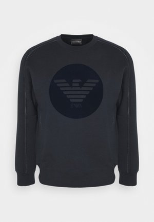 Schwarzes Sweatshirt mit langen Ärmeln und Rundhalsausschnitt, vorne mit einem dezenten, dunklen runden Logo mit stilisierten Flügeln und Buchstaben.