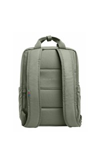 Zaino in tessuto verde con schienale imbottito, spallacci regolabili, tasca laterale e logo "CREA UN IMPATTO" sul davanti. Caratterizzato da una superficie liscia.