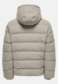 Beige polstret jakke med hætte, med et quiltet design og en glat tekstur. Bagsiden har syede vandrette linjer til isolering.