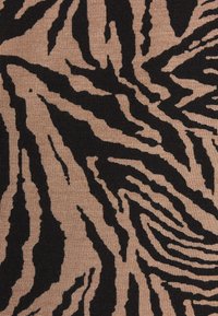 Geweven stof met een gedurfde zwarte zebraprint op een beige achtergrond, die een gestructureerde, geweven uitstraling toont.