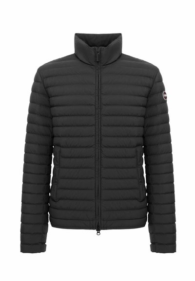 Veste matelassée noire avec col haut, fermeture éclair frontale, poches latérales et écusson logo sur la manche gauche.