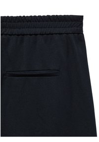 Gros plan sur un pantalon en tissu noir avec une ceinture élastique et une poche passepoilée horizontale sous la ceinture dans le dos.