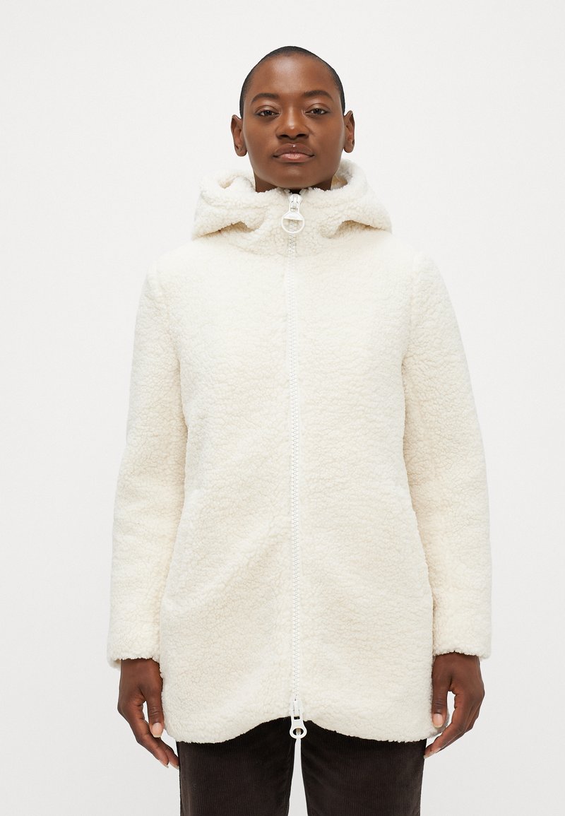 Veste en polaire blanche avec capuche, dotée d'un zip frontal complet, d'une texture douce et d'un ourlet arrondi. Manches longues et détails minimalistes.
