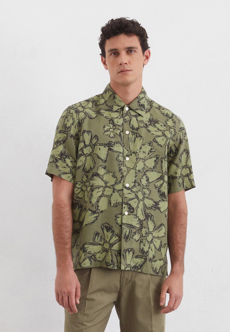 Korte mouwen shirt van groene katoen met zwart bloemenprint, met een kraag en een sluiting met knopen aan de voorkant. Soepele textuur en losse pasvorm.