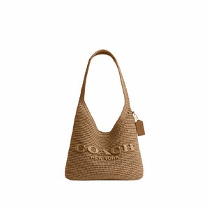 Pruun kootud Coach New York õlakott lai rihma ja nahast sildi ripub kuldse ahela küljes ühevärvilisel taustal.