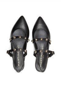 Zapatos slingback de cuero negro con puntas afiladas, que presentan dos correas adornadas con clavos dorados. Textura suave con suela plana.