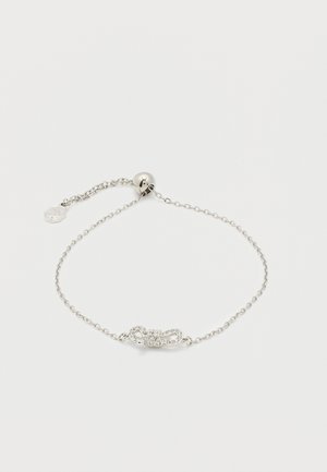 Delikatna srebrna narukvica s lancem, s podesivim okruglim kopčom i središnjim privjeskom u obliku mašne ukrašenim malim kristalima.