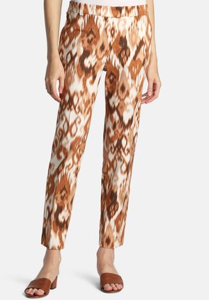 Vzorované nohavice s úzkym strihom, ktoré majú abstraktný hnedo-krémový dizajn. Vyrobené z hladkej tkaniny s pohodlným pásom.