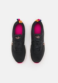 Černé sportovní boty s texturovaným svrchním dílem, růžovou stélkou, bílou mezipodešví a barevnými patními pásky v oranžové, modré a růžové barvě.