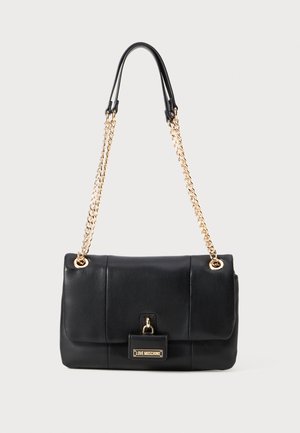 Saco de pele preto com correntes douradas e um flap frontal apresentando uma pequena placa em dourado com o logo "Love Moschino".