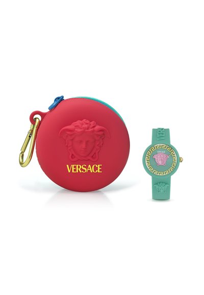 Rote Silikon-Tasche mit einem goldenen Clip, der ein erhabenes Medusa-Logo und den Text "VERSACE" zeigt. Begleitet von einer türkisfarbenen Uhr mit ähnlichen Designelementen.