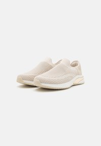 Beige slip-on sneakers med ovandel i stickat material, mönstrad struktur, lätt sula och en cremefärgad detalj på hälen för extra stöd.