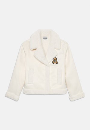 Veste en fausse fourrure blanche avec un col cranté, deux poches avant et un logo d'ours brodé sur le côté gauche. Texture douce et design cropped.
