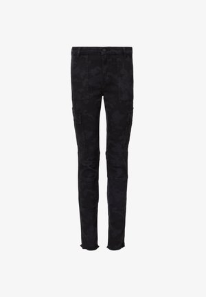 Black camo cargo pants with multiple pockets, slim fit, zipper accents at the ankles, and a slightly distressed hem. Made from denim.