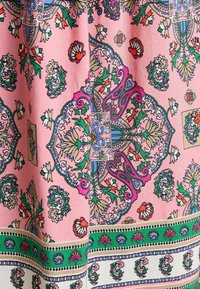 Rosa gemusterter Stoff mit komplizierten floralen und geometrischen Designs in grünen, blauen und orangefarbenen Akzenten, mit einer strukturierten Oberfläche.