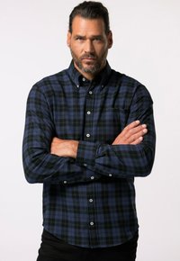 Camicia a quadri blu e verde, in tessuto flanella, maniche lunghe, colletto, bottoni bianchi, orlo curvo, con una tasca sul lato sinistro.