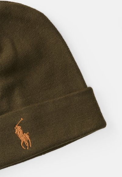 Stickad olivgrön mössa med uppvikt kant och en broderad ljusbrun polo-spelare logotyp på sidan. Mjuk, texturerad finish.