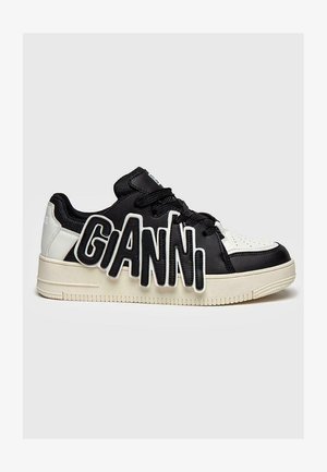 Zwart-witte sneaker met een gestructureerde bovenkant, een oversized "GIANNI" logo aan de zijkant en een dikke witte rubberen zool.