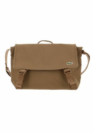Sac messager rectangulaire marron avec fermeture à rabat, deux sangles avant à boucle, une petite poignée sur le dessus et un logo crocodile brodé.