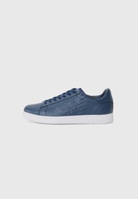 Navy blue leather sneakers with white rubber sole, round toe, and embossed logo on the side. Features blue laces and padded ankle support.