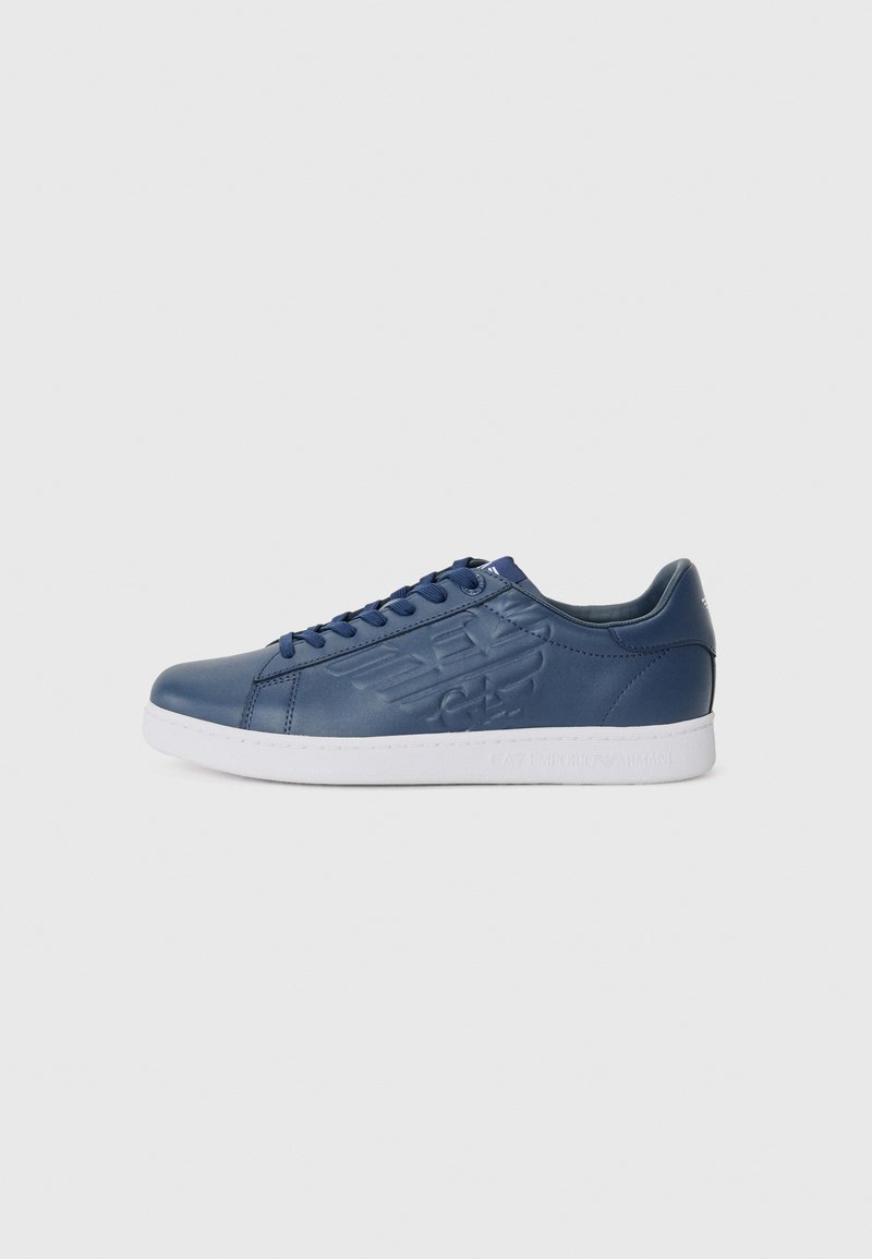 Navy blue leather sneakers with white rubber sole, round toe, and embossed logo on the side. Features blue laces and padded ankle support.