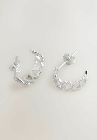 Cercei cerc cu inele argintii, cu decupaje în formă de inimă, finisaj lucios și închidere sigură cu suport. Design elegant circular cu accente texturate.