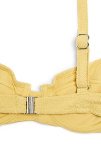 Soutien-gorge en tissu texturé jaune avec bretelles réglables et fermoir métallique argenté sur fond blanc.