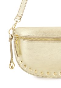 Metallisch goldene Lederhandtasche mit geschwungener Form, Oberreißverschluss, dekorativen goldenen Nieten entlang der Kante und einem verstellbaren Trageriemen.
