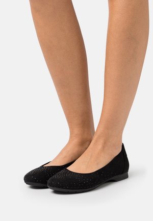 Ballerines en daim noir avec un bout rond, des détails cloutés à l'avant et une semelle en caoutchouc basse et flexible.