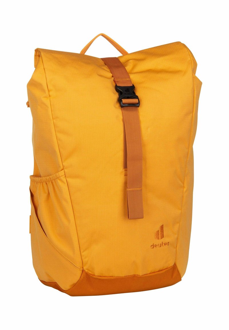 Mochila de tela amarilla con diseño de cierre enrollable, correa ajustable, bolsillo lateral y un broche negro. Presenta un sutil branding en la parte frontal.