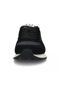 Scarpe da ginnastica nere con tomaia in suede e mesh, dotate di linguetta imbottita, lacci piatti e suola in gomma bianca e nera.