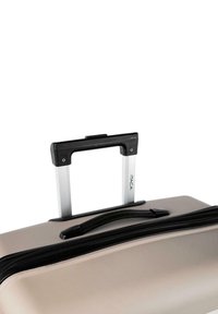 Maleta rígida en beige con cremallera negra, con un asa extensible plateada y un mango ergonómico negro.