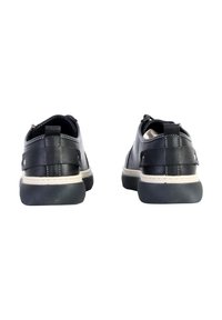 Black leather shoes with a smooth texture, rounded design, subtle stitching, and contrasting white midsole. Features a back tab for easy wear.
