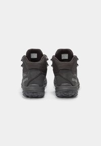 Zapatos de senderismo negros con parte superior texturizada y talón reforzado. Presentan una suela de tacos pronunciados para tracción y un logo en el costado.