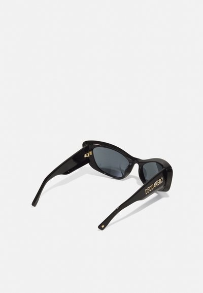 Black sunglasses with a sleek, angular design and dark lenses. Features gold "DSQUARED2" branding on the temples. Smooth plastic texture.